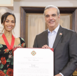 Zoe Saldaña y Luis Abinader sonríen mientras sostienen Orden Heráldica de Cristóbal Colón. FOTO: PRESIDENCIA DE LA REPÚBLICA DOMINICANA