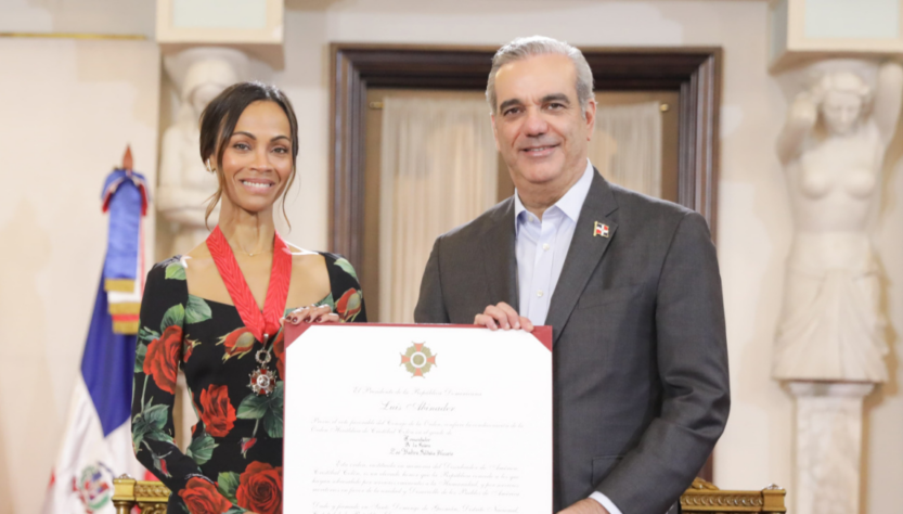 Zoe Saldaña y Luis Abinader sonríen mientras sostienen Orden Heráldica de Cristóbal Colón. FOTO: PRESIDENCIA DE LA REPÚBLICA DOMINICANA