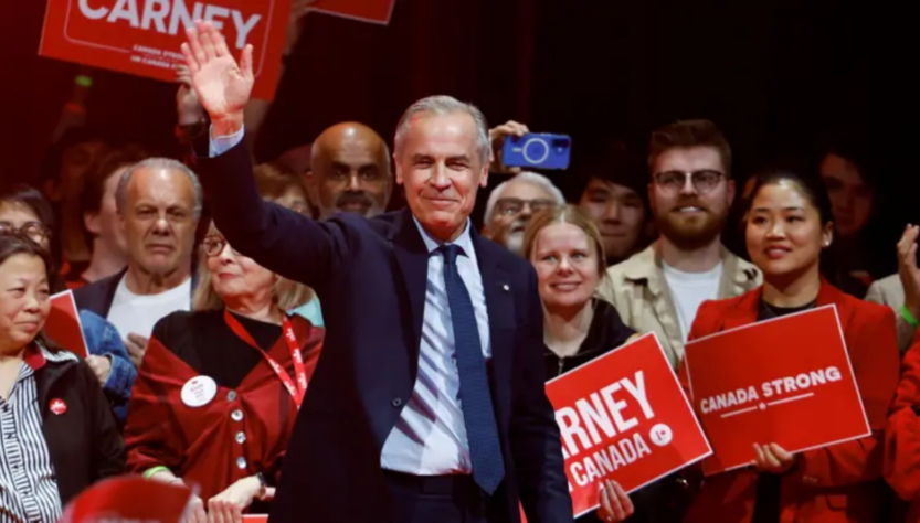 Mark Carney saluda al público con su mano derecha, detrás de él simpatizantes de su campaña. FOTO: REUTERS