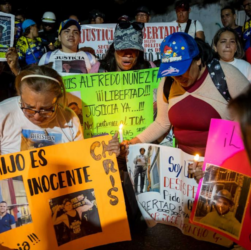 Migrantes venezolanos con carteles piden la libertad de sus familiares a Nayib Bukele. FOTO: EFE